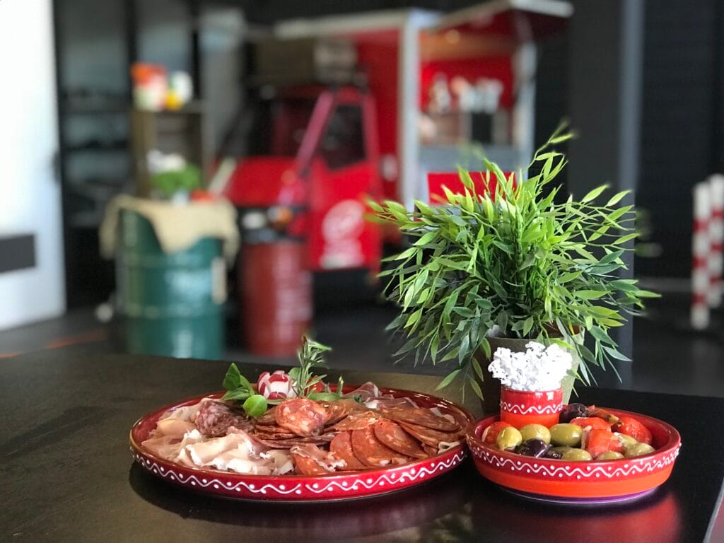 Schaals met Italiaanse antipasti, vleeswaren en olijven van Capri Culinair op een tafel.