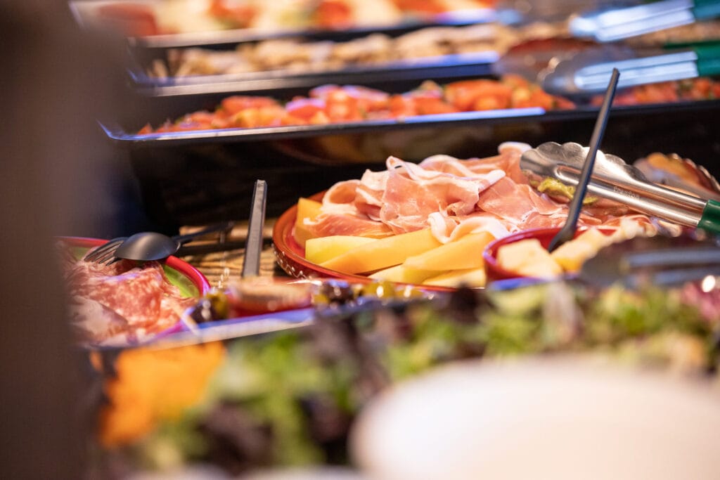 Sfeervol Italiaans antipasti buffet van Capri Culinair bij LEVS Architecten met prosciutto met meloen en diverse delicatessen.